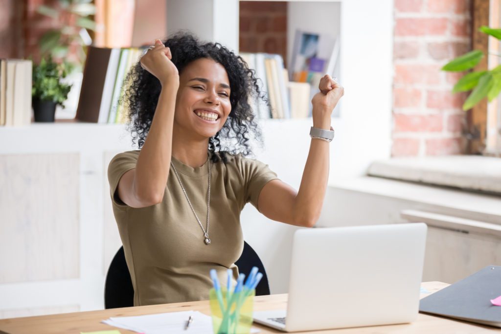 woman smiling with arms up