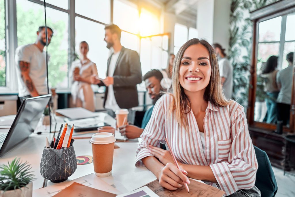 Smiling female employee sitting in coworking space