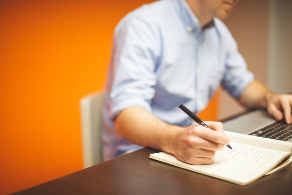 man writing notes